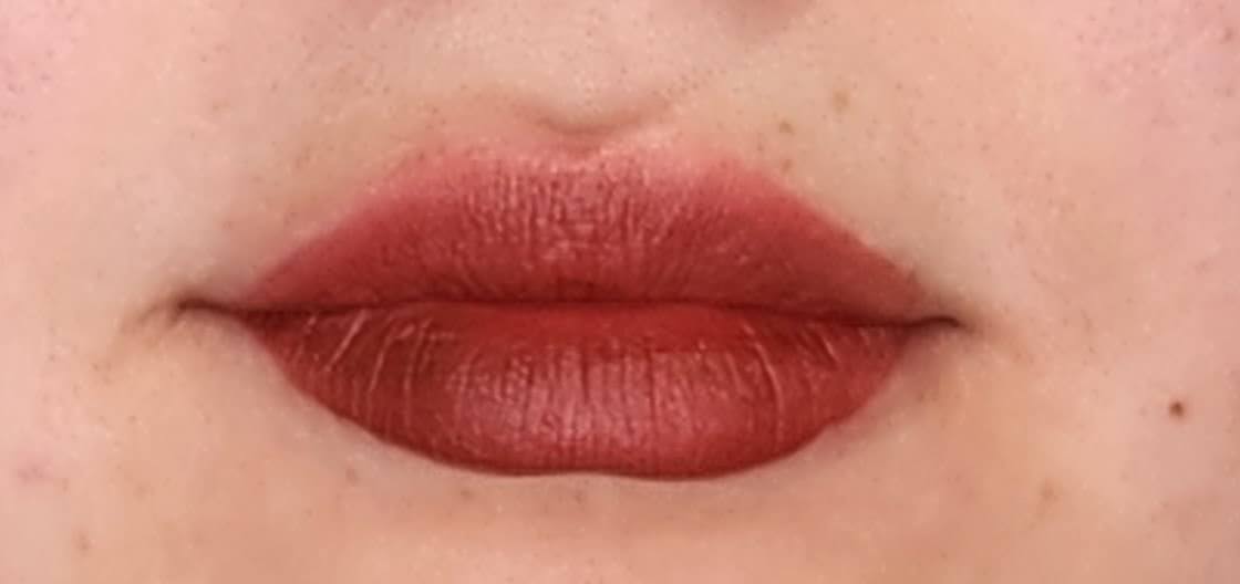 Women wearing Frankie Blair Matte Lip Stain Desert Rani, A reddish brown lip stain that is long lasting and hydrating.