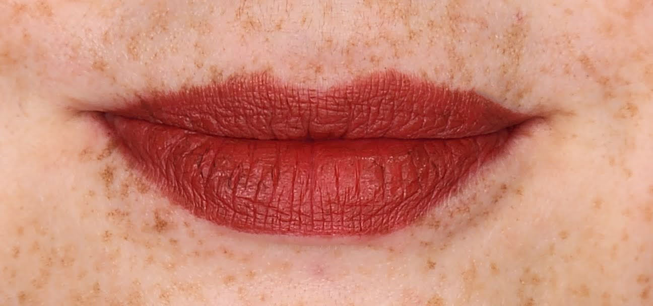 Women wearing Frankie Blair Matte Lip Stain Desert Rani, A reddish brown lip stain that is long lasting and hydrating.